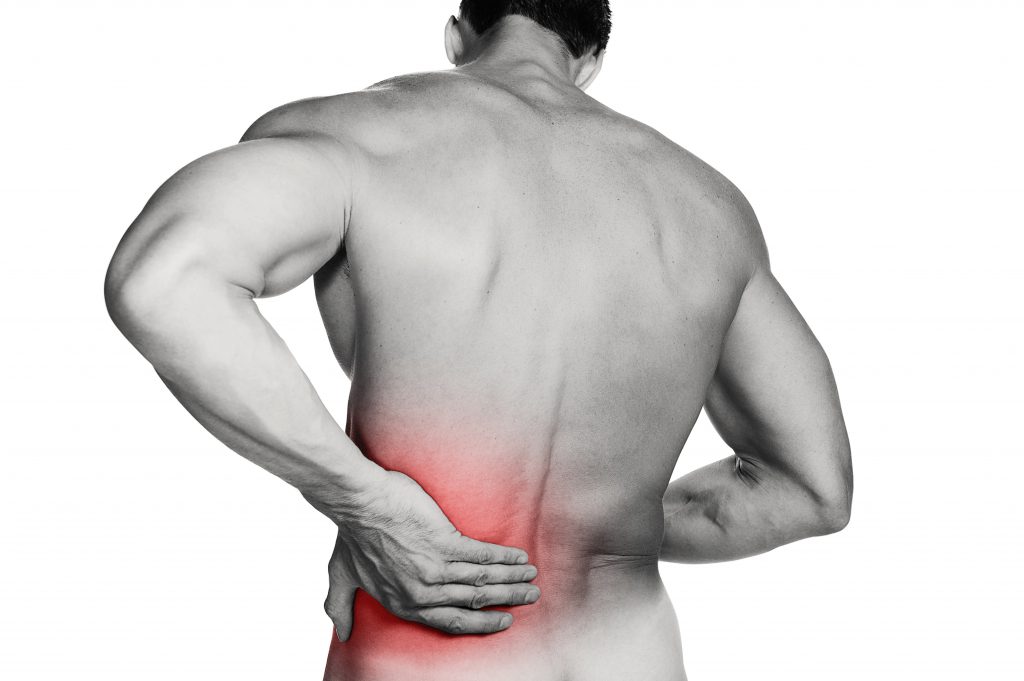 Black and white photo of a muscular man with a backache. Red selective color further illustrates pain. Clipping path included so image can be easily transferred to a different colored background.
